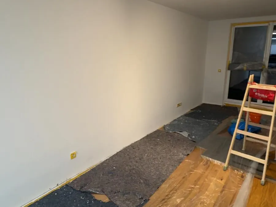 Wohnraum nach der Schimmelsanierung in Axams, Wände neu beschichtet, Boden noch abgedeckt